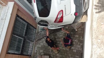 Defne’de otomobil bina boşluğuna devrildi