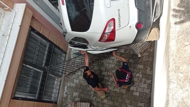 Defne’de otomobil bina boşluğuna devrildi